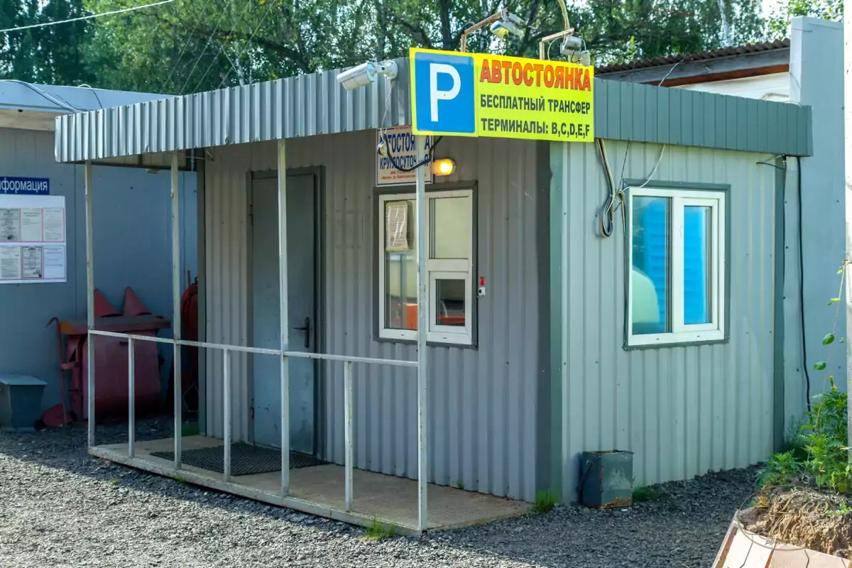 Вывеска Parking-S о бесплатном трансфере в терминалы B, C, D, E, F и камеры над постом